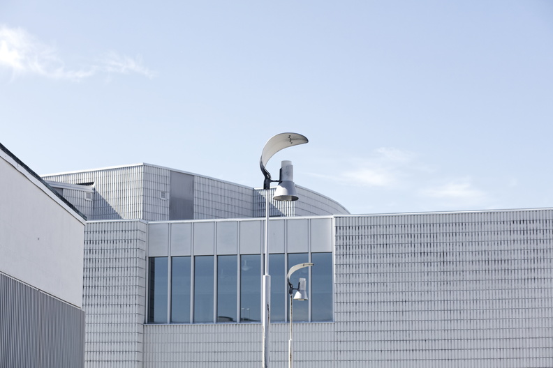 Nykyaikainen rakennus, jossa lasinen julkisivu ja metallinen ilmanvaihtotorni, taustalla sininen taivas. Alvar aalto. Seinäjoki