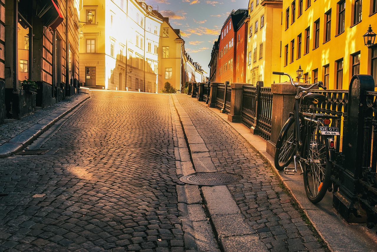 Ruotsi. Tukholma on kaunis ja eläväinen matkailukaupunki. Kapea mukulakivikatu, värikkäät rakennukset ja pysäköity polkupyörä auringonlaskun valossa.