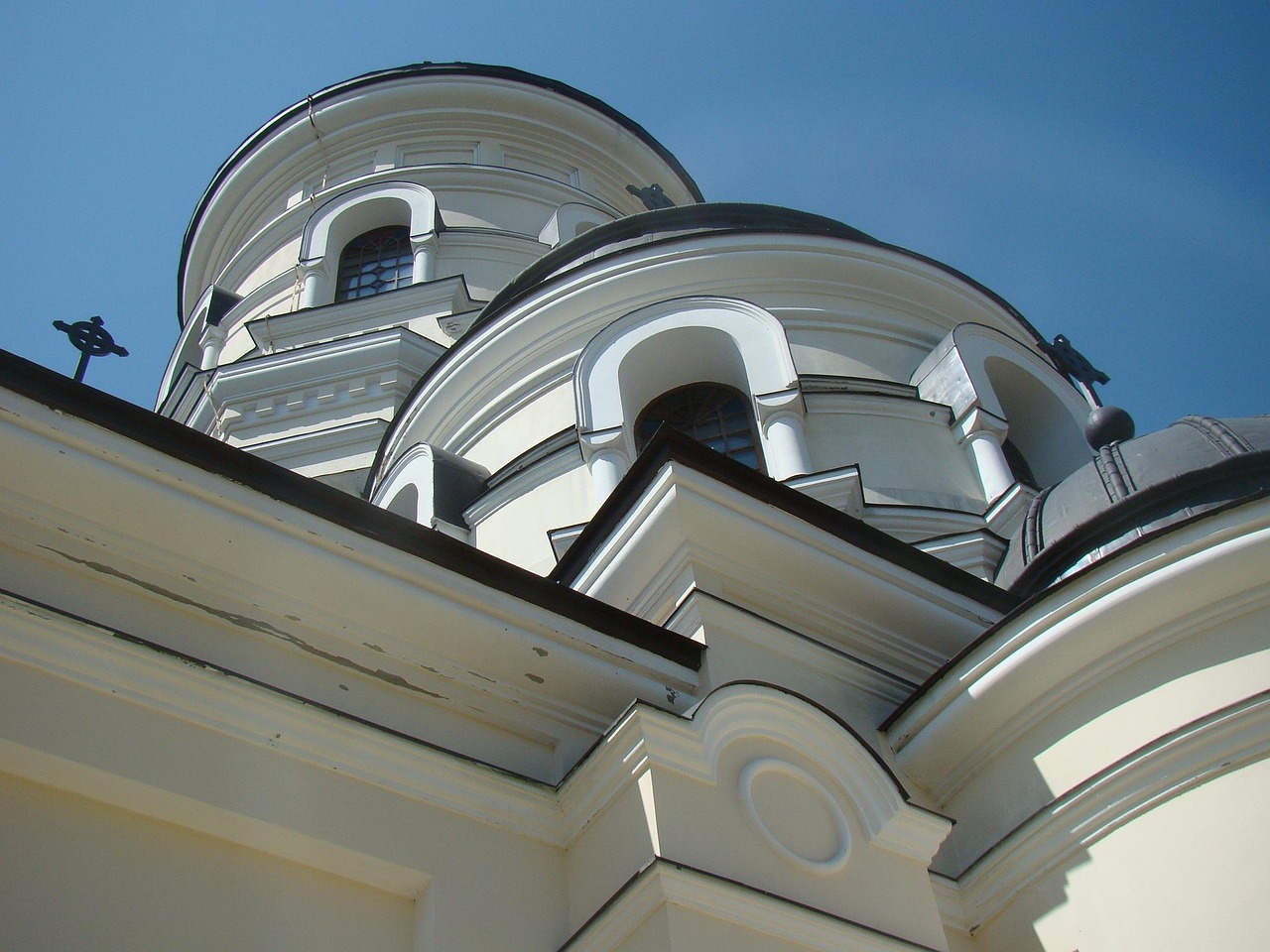 Moldova, Chișinău on kaunista arkkitehtuuria. Valkoinen uusklassinen rakennus, kupolit ja pylväät näkyvät alakulmasta sinistä taivasta vasten.