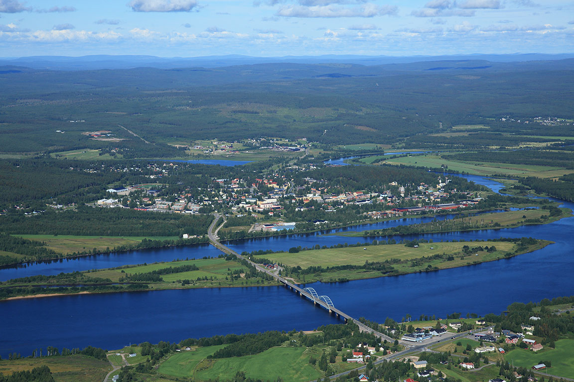 Ylitornio on rajakunta Ruotsin Övertorneån kanssa.
Ilmakuva laaksosta, joesta ja sillasta, ympärillä vihreitä peltoja, kyliä ja metsää.