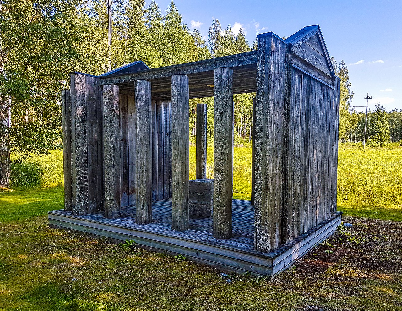 Carolus Enckellin Temppeli, Viitasaarella. Tuulensuun veistospuisto.
Siniseksi patinoitunut puinen rakennelma, jossa on avoin sisätila ja pylväitä metsäisessä puistossa.