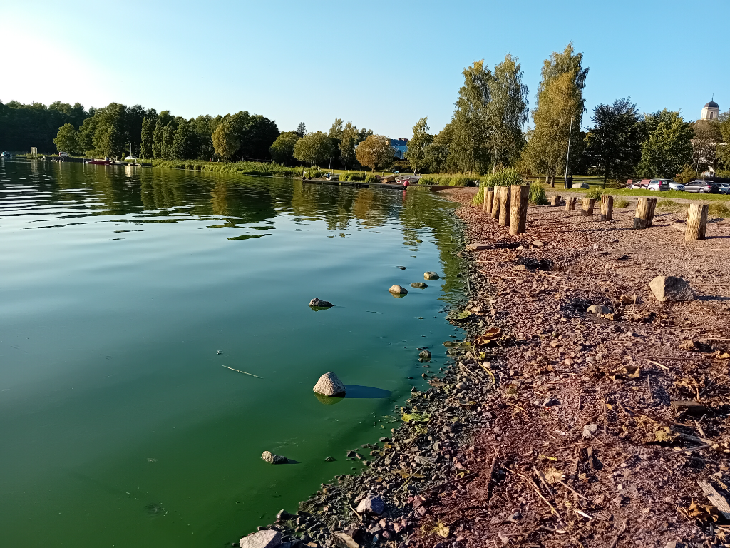Hiidenvesi, tarjoaa erinomaiset mahdollisuudet lomailuun Vihdissä.
Järven rantaa, vihreää vettä, kivikkoista polkua ja puupölkkyjä, taustalla puita ja veneitä.