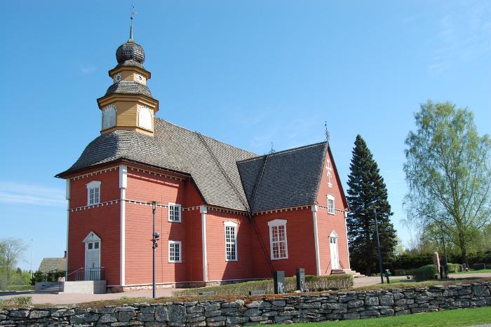 Säkylän puinen kirkko, valmistui vuonna 1776.
Punatiilinen kirkko, jossa kellotorni ja sininen katto, taustalla puisto ja kivimuuri.