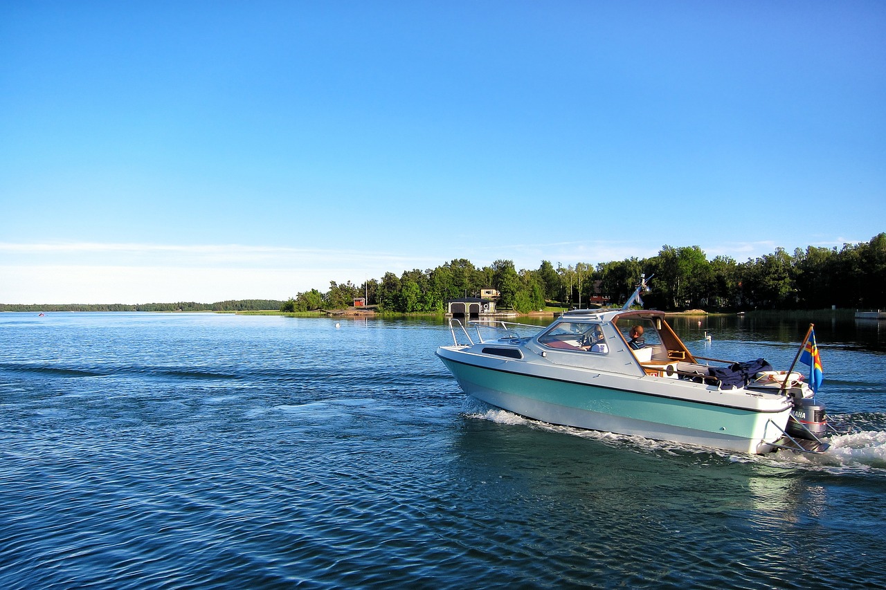 Sottunga on pieni, rauhallinen saaristokunta.
Valkoinen moottorivene liukuu järvellä, sininen taivas ja metsäranta näkyvät taustalla.