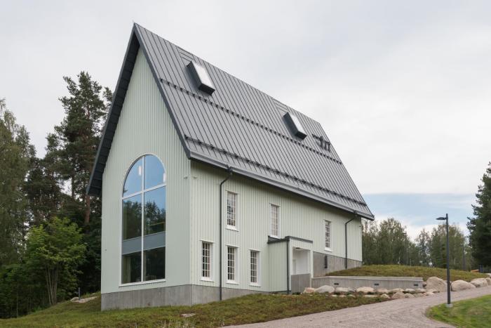 Rautjärven uusi kirkko valmistui 2025 edellisen tuhopoltossa tuhoutuneen kirkon tilalle.
Valkoinen moderni rakennus, jossa on kalteva harjakatto ja suuret ikkunat, ympärillä metsää ja nurmikkoa.