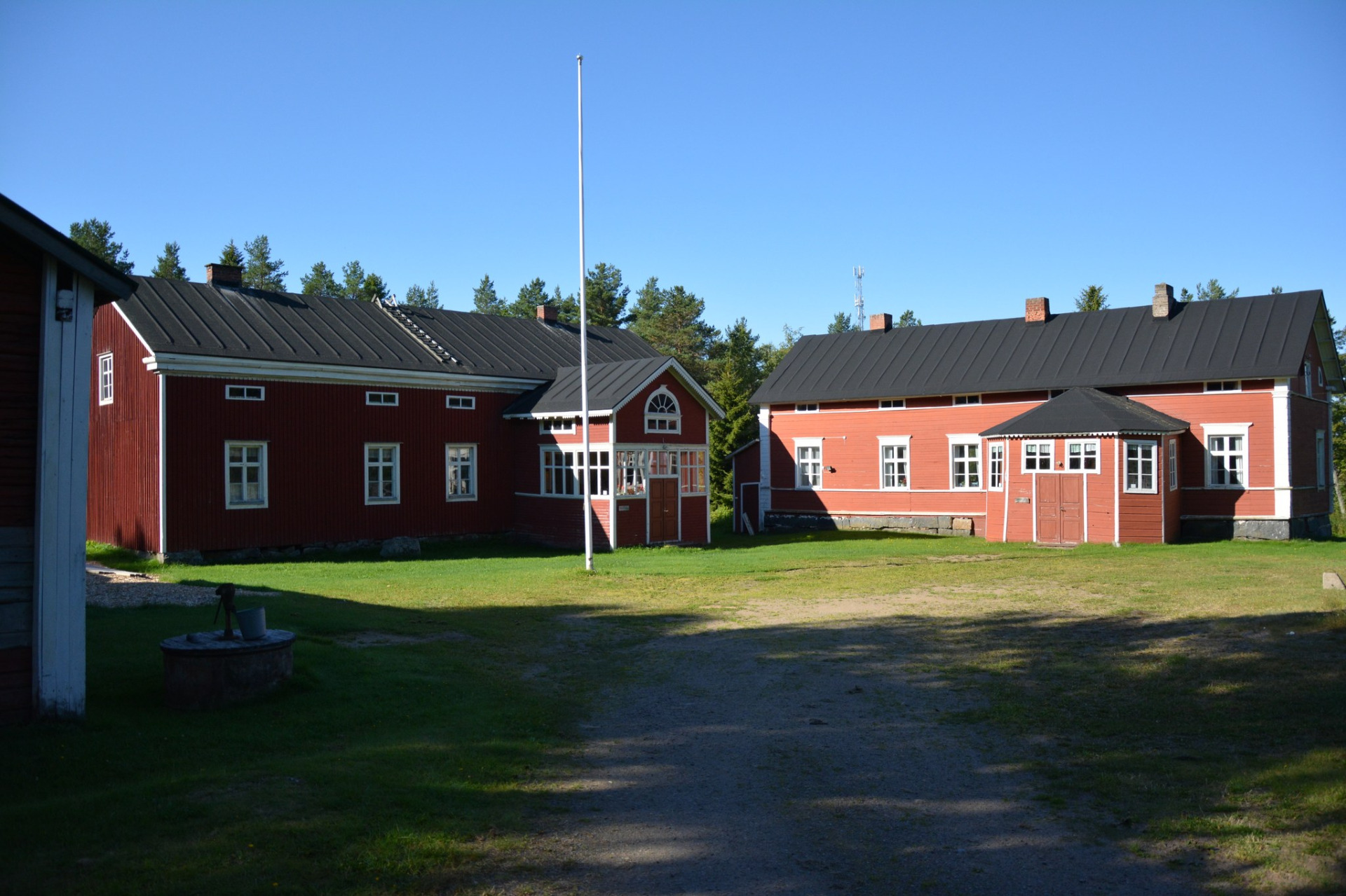 Annalan Kotiseutumuseon alueella on 22 rakennusta, joista löytyy liki 8000 esinettä.
Punaiset hirsitalot ja harmaat katot, keskellä korkea lipputanko, nurmipiha ja sininen taivas.