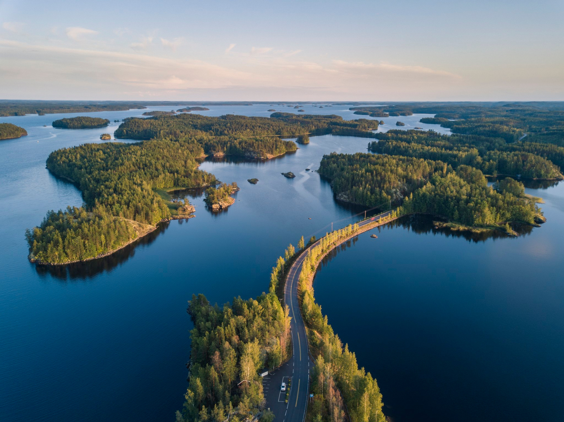 Lietveden maisematie Puumalassa Etelä-Savossa
Ilmakuva järvimaisemasta, metsäsaarista ja kapeasta tiestä, joka kaartuu veden yli.
