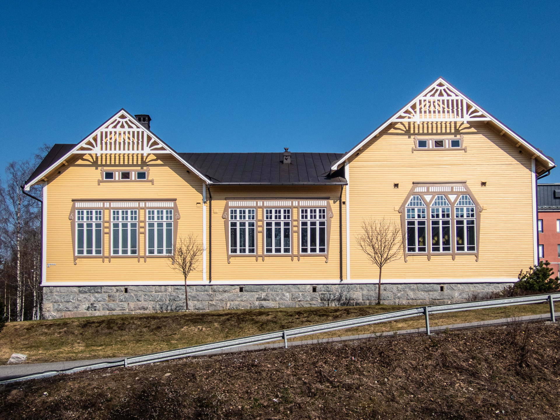 Vanha Puu-Nurmes on kaunis asuinalue Nurmeksen kaupungissa.
Keltainen puutalo, jossa jyrkkä harjakatto, koristeelliset päädyt ja suuret ikkunat sinistä taivasta vasten.