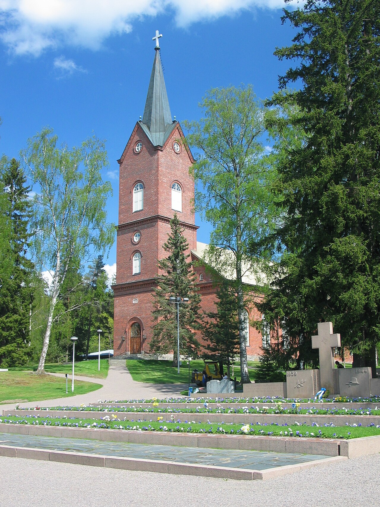 Mäntsälän kirkko on vihitty käyttöön vuonna 1866.
Punatiilinen kirkko, korkea kellotorni ja risti, ympärillä vihreää puistoa ja kukkakiveystä.