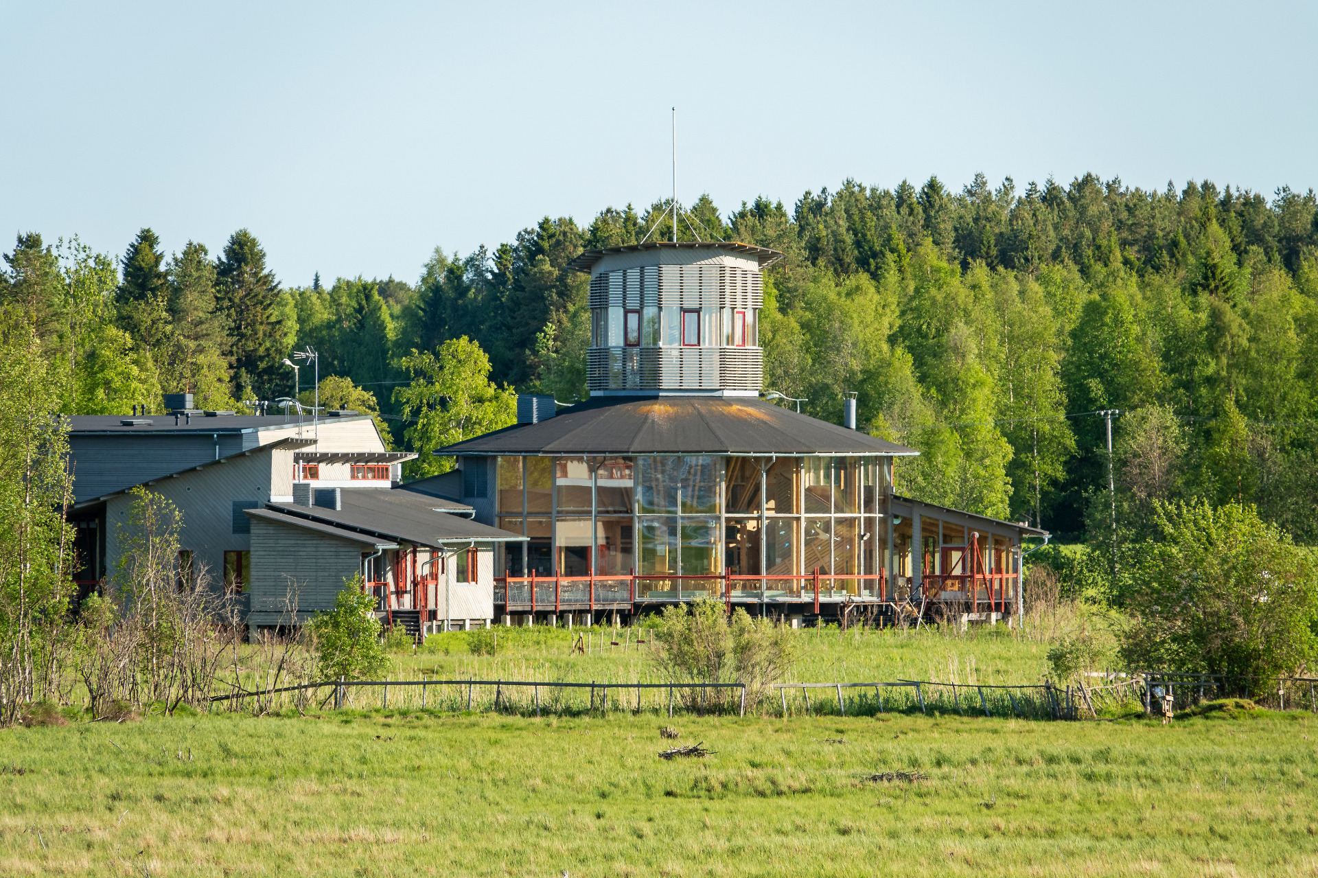 Liminganlahden luontokeskus Pohjois-Pohjanmaalla.
Moderni rakennus ja lasinen terassi, korkea torniosa, ympärillä metsää ja vihreää nurmikkoa.