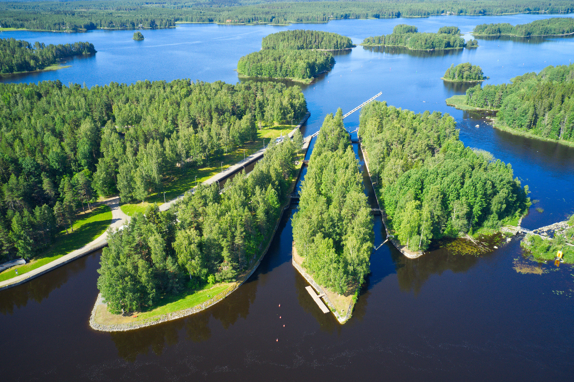 Konnuksen kanava, Leppävirta
Ilmakuva järvestä ja joesta, vihreistä saarista, puistokäytävistä sekä sillasta ja laiturista.