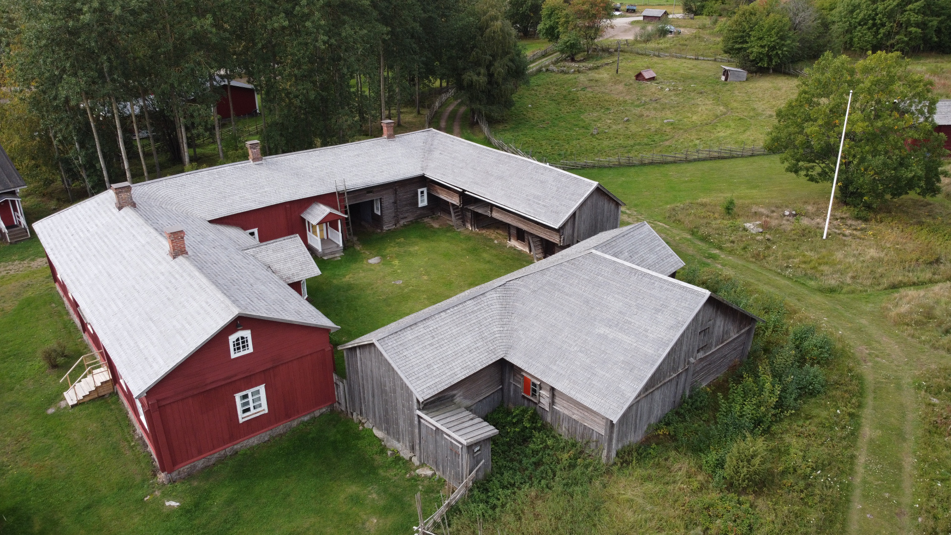 Kauppilan umpipiha on tunnetuin museokohde Laitilassa.
Ilmakuva punaisesta ja harmaasta maatilasta, harmaakattoisista rakennuksista ja vihreästä pihapiiristä metsän keskellä.