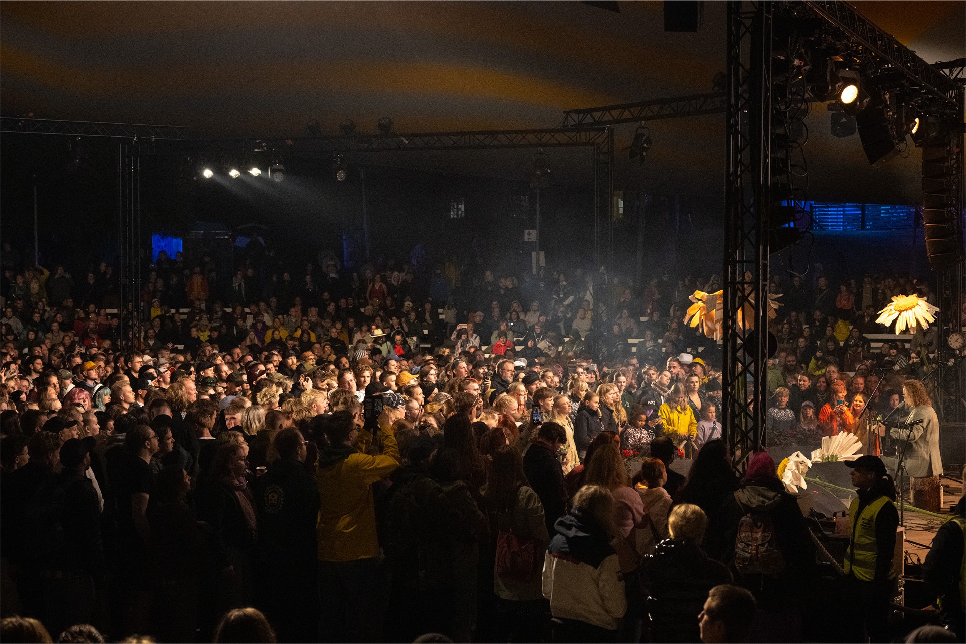 Kaustinen Folk Music Festival Keski-Pohjanmaalla.
Tuhansien ihmisten täyttämä konserttiareena, lavalla esiintyjä ja keltaiset valot, savua ja valokiiloja.
